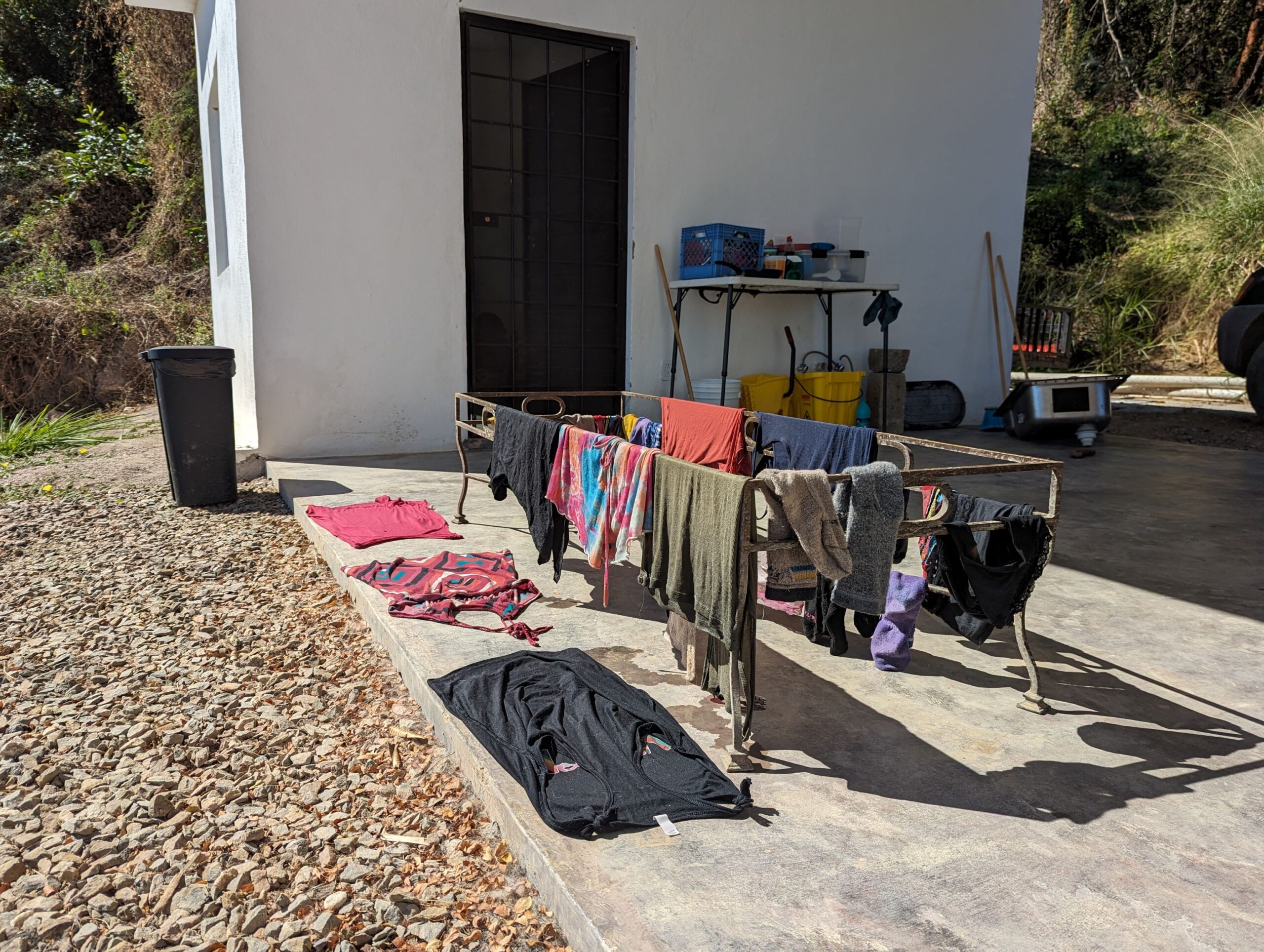 Clothing laid out on the floor and table to dry in the sun.