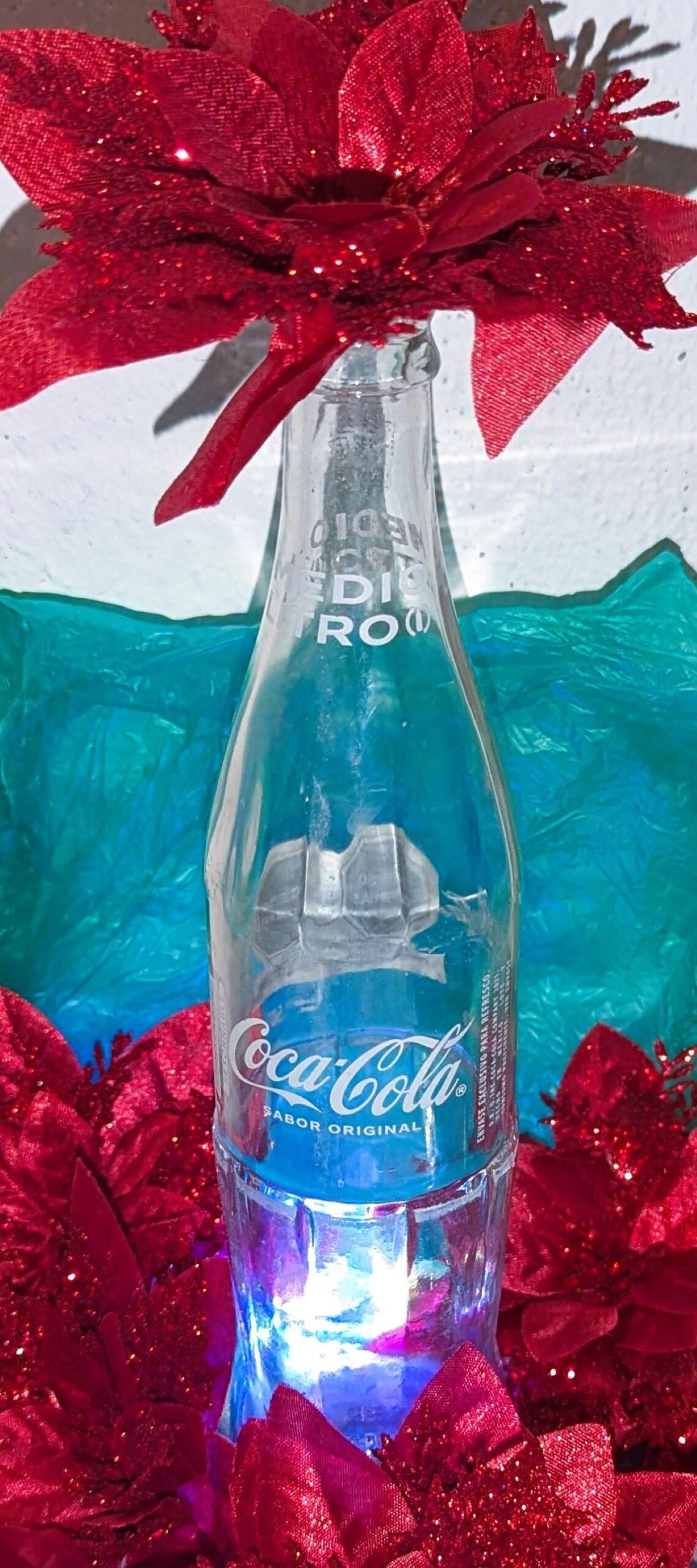 Coca-cola bottle decorated with poinsettias