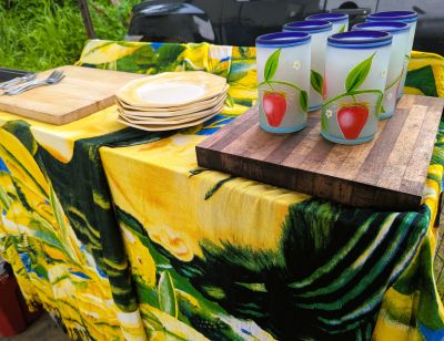 Yellow ceramic plates and frosted glasses on a covered sideboard.